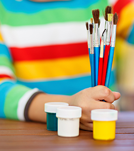 Kindergarten student getting ready to paint with colorful colors